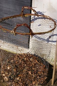 a pile of leaves sitting in front of a building next to a wire fence and door