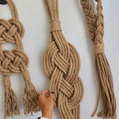 someone is pulling the ends of two large rope pieces off of each other with their hands