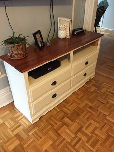 an entertainment center in the corner of a room with wood flooring and white furniture