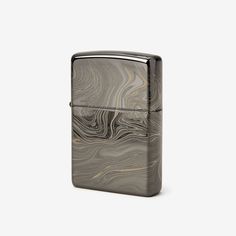 a black and silver zippo lighter on a white background with an image of waves