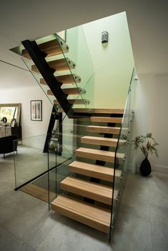 a staircase with glass railing and wooden steps