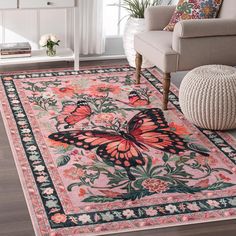 a pink rug with a butterfly on it in front of a couch and chair next to a window