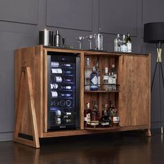 a wooden cabinet with bottles and glasses on it