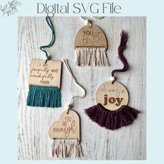 three wooden ornaments with tassels and words on them