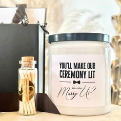 a candle and some matches are on a table next to a box that says, you'll make our ceremony lit