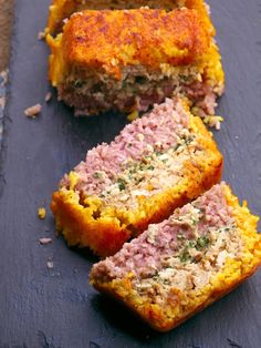 some meatloaf is cut in half on a slate board