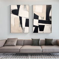 two paintings hang on the wall above a couch