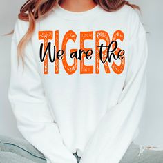 a woman wearing an orange and white sweatshirt with the words, we are the on it