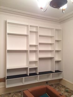 an empty room with white shelves and blue boxes on the floor in front of it