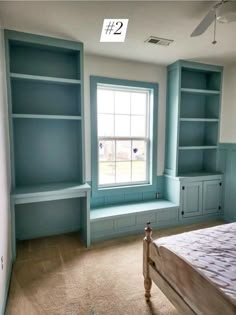 an empty bedroom with blue bookcases and a bed in it's corner