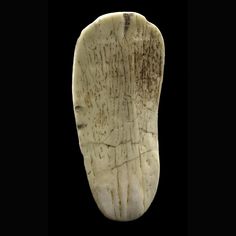 a piece of white marble with writing on it's side, in the shape of a foot