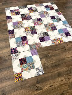 the finished quilt is laid out on the floor