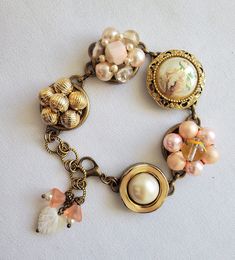 This beautiful bracelet has been made from 5 vintage earrings! The earrings are in light dusty peach, cream and gold. The bracelet is adjustable from 7 to 8 inches and has a mother of pearl  heart and peach glass bell flower charms.  The bracelet will arrive wrapped in tissue and in a silver gift bag.  It will be mailed USPS,  Ground Advantage with tracking and insurance,  in a small cardboard box. Vintage Rose Gold Jewelry For Vintage Collection, Adjustable Peach Bracelet, Adjustable Nickel-free Cream Jewelry, Vintage Rose Gold Jewelry From Vintage Collection, Adjustable Cream Nickel-free Jewelry, Vintage Beige Bracelet, Vintage Pink Bracelets For Wedding, Adjustable Vintage Rose Gold Jewelry, Bohemian Peach Jewelry For Gifts