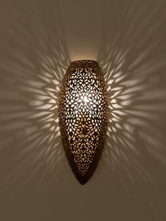 an intricately designed wall light casts a shadow on the wall