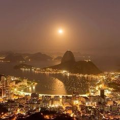 the full moon shines brightly over a city at night