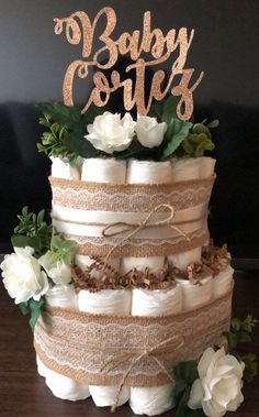 a diaper cake that is decorated with flowers and the words baby cots on top