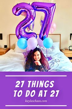 a woman laying on top of a bed with balloons in the shape of the number twenty