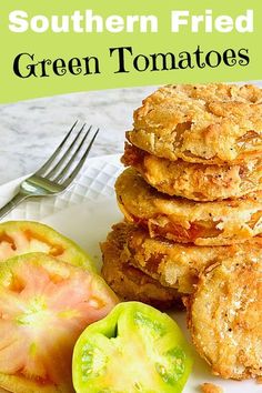 a plate topped with fried green tomatoes next to a pile of fried breaded patties