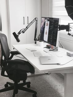 an office desk with a computer and microphone