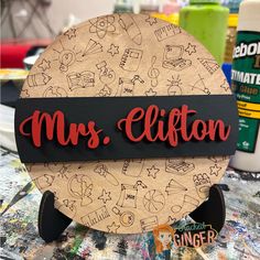 a wooden sign that says mrs hilton on it's face and is surrounded by other crafting supplies