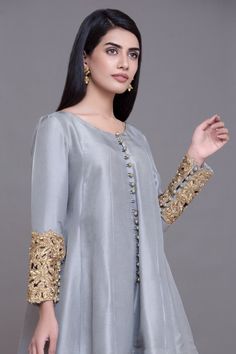 Simple Chiffon Suit for Party in Ice Blue Color with Magnificent Look emblazoned with beautiful embroidery, dabka and sequins. This party dress is unique in style and have classy look and perfect choice for wedding party. Frock: Short frock for party dress in ice blue color is embellished with fully copper color embroidery, dabka, nakshi, stones, cutdana, on full length sleeves. Fabric used for shirt is chiffon. Trouser: Stylish trouser in skin color is paired with this party dress. Trouser fabr