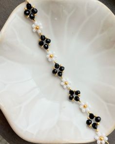 a black and white beaded necklace on a plate