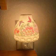 a lamp that is sitting on top of a wooden table next to a white wall