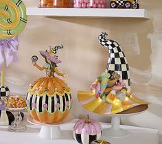 three decorative pumpkins on display with candy in the background