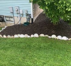 a pile of dirt sitting in the middle of a yard next to a tree and power lines