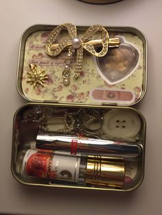 two tins filled with various items on top of a table