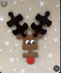 a wooden reindeer ornament with eyes and nose on a white snowflakes background