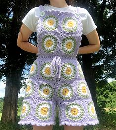 a woman wearing a purple crocheted dress with sunflowers on it