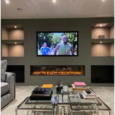 a living room with two couches and a large television mounted to the wall above it