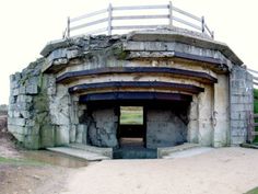 an old stone structure with a wooden fence around it's entrance to the park