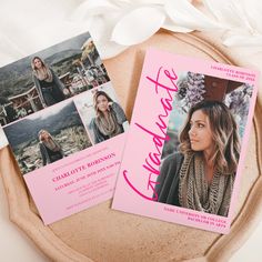 two pink and black graduation announcement cards on a plate