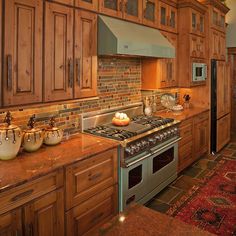 a kitchen with wooden cabinets and granite counter tops, including a stove top oven in the center