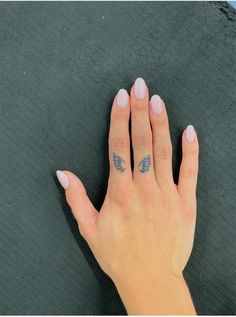 a woman's hand with a small butterfly tattoo on her left thumb and finger