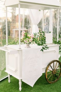 a white cart with flowers and greenery on it