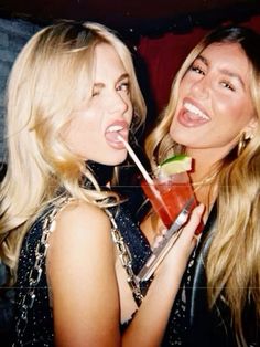 two beautiful young women drinking cocktails at a party