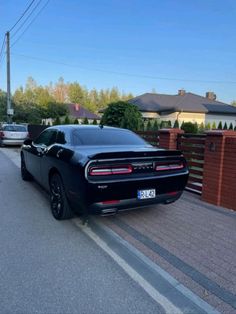 a black car is parked on the side of the road