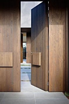 two wooden doors open on the outside of a house