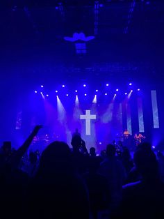 a group of people standing on top of a stage with purple lights in the background