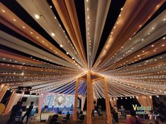 the ceiling is decorated with lights and draping for a wedding or event reception