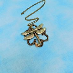 Non tarnish vintage bronze and gold colored copper wire is hand woven and sculpted in the shape of a very large flower. A large brass colored dragonfly hovers in the center. This is a substantial pendant that would make a statement with any outfit. The pendant measures 3 inches by 3 inches and comes with a FREE coordinating chain, measured to your desired length. Your one of a kind necklace is ready to ship via USPS to your US location at no extra cost. (International shipping available. Please Handmade Adjustable Antique Gold Necklace, Bohemian Gold Soldered Jewelry, Handmade Antique Gold Metal Necklace, Antique Gold Handmade Jewelry For Festivals, Gold Antique Finish Copper Necklaces, Gold Copper Necklace With Antique Finish, Unique Gold Necklaces With Antique Finish, Unique Gold Necklace With Antique Finish, Handmade Antique Gold Brass Necklace