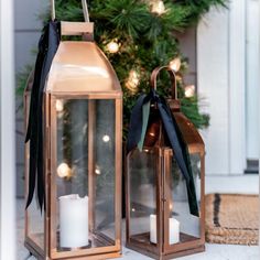 two lanterns sitting next to a christmas tree