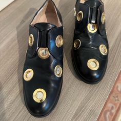 Crafted From Black Supple Leather, These Truly Unique Cavallini Slip-On Style Loafers Feature A Rounded Toe, Large Eye-Catching Gold-Tone Metal Eyelets On The Upper, An Elasticated Front Closure, Nude Leather Insoles And Lining, And A Wide Block Heel Embellished With Gold-Tone Hardware And Crystal Studs. Stunning Shoes - A Total Statement Piece!! Smoke Free And Pet Free Home. Designer Pointed Toe Leather Shoes For Party, Designer Leather Shoes With Pointed Toe For Party, Designer Leather Party Shoes, Elegant Leather Shoes With Perforations And Round Toe, Round Toe Loafers For Evening In Spring, Evening Loafers With Round Toe For Spring, Spring Evening Loafers With Round Toe, Spring Evening Leather Shoes With Round Toe, Designer Leather Shoes With Round Toe For Evening