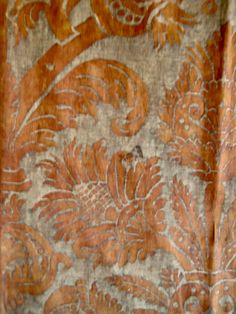 an orange and brown floral design on fabric