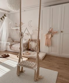 a white bedroom with a swing bed and baby crib in the corner next to it