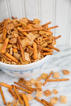 a white bowl filled with cheetos sitting on top of a marble countertop