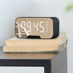 an alarm clock sitting on top of a stack of books